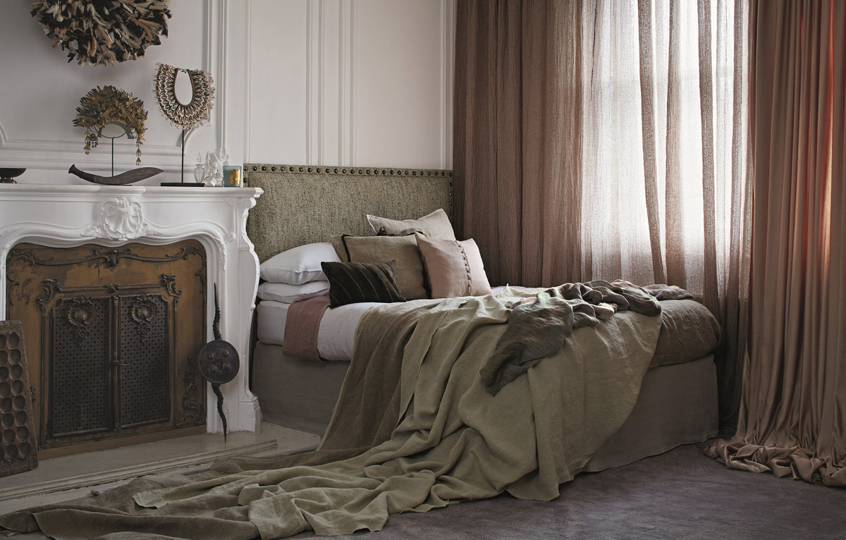 Cosy bedroom with linen bedding and curtains